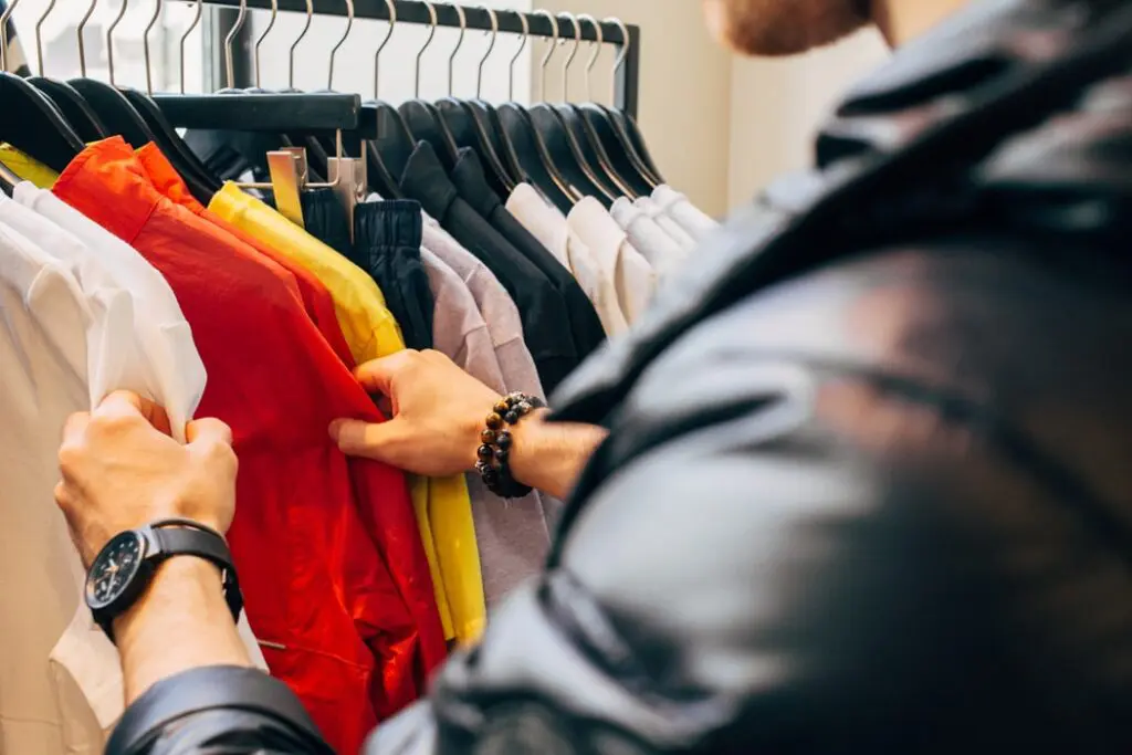 Comprar compulsivamente é doença? Homem Analisando Roupas